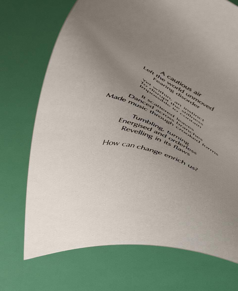 Curved cream paper with poem text set against a muted green background.