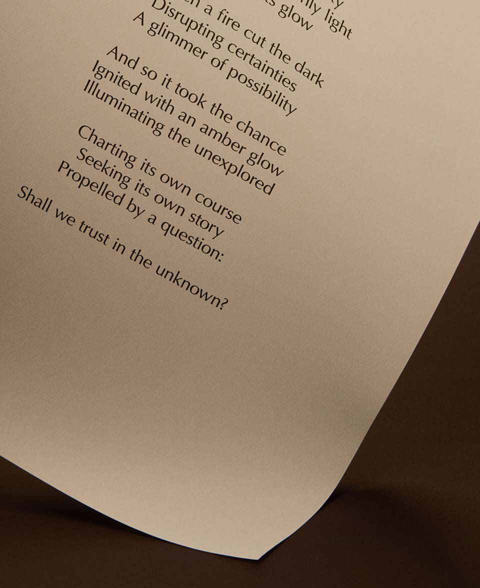 Curved page with printed poem text on a warm dark-brown background.