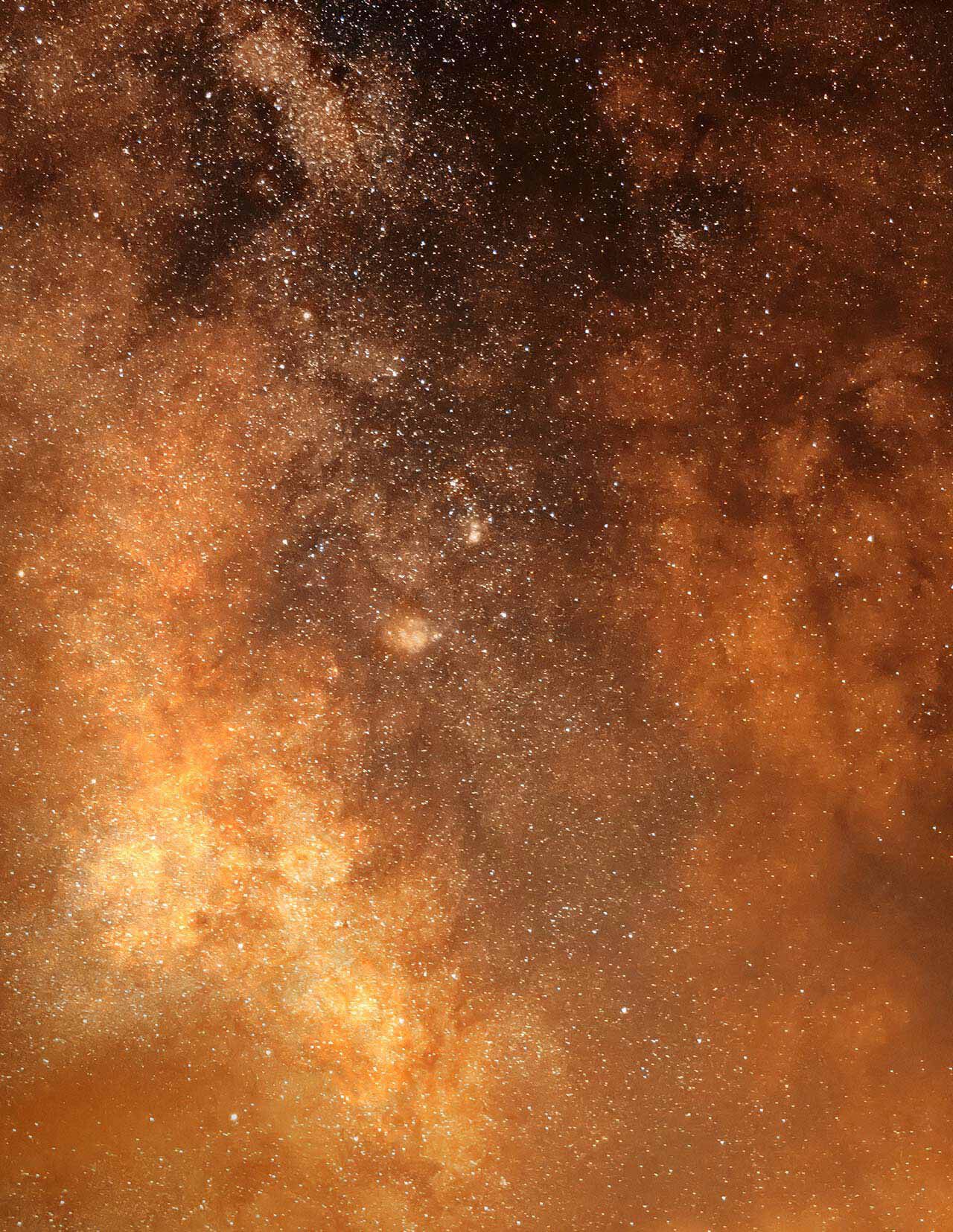 Amber and golden cloud-like light with dense speckled particles, creating a textured celestial composition against darker burnt-orange areas.