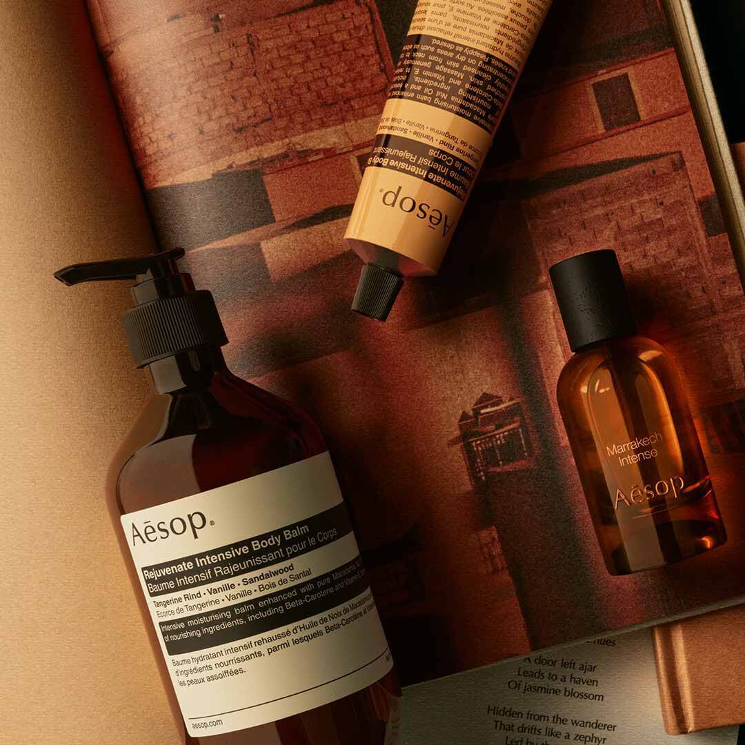 Aesop Marrakech Intense bottle with pump bottle and yellow tube arranged on warm-toned papers.