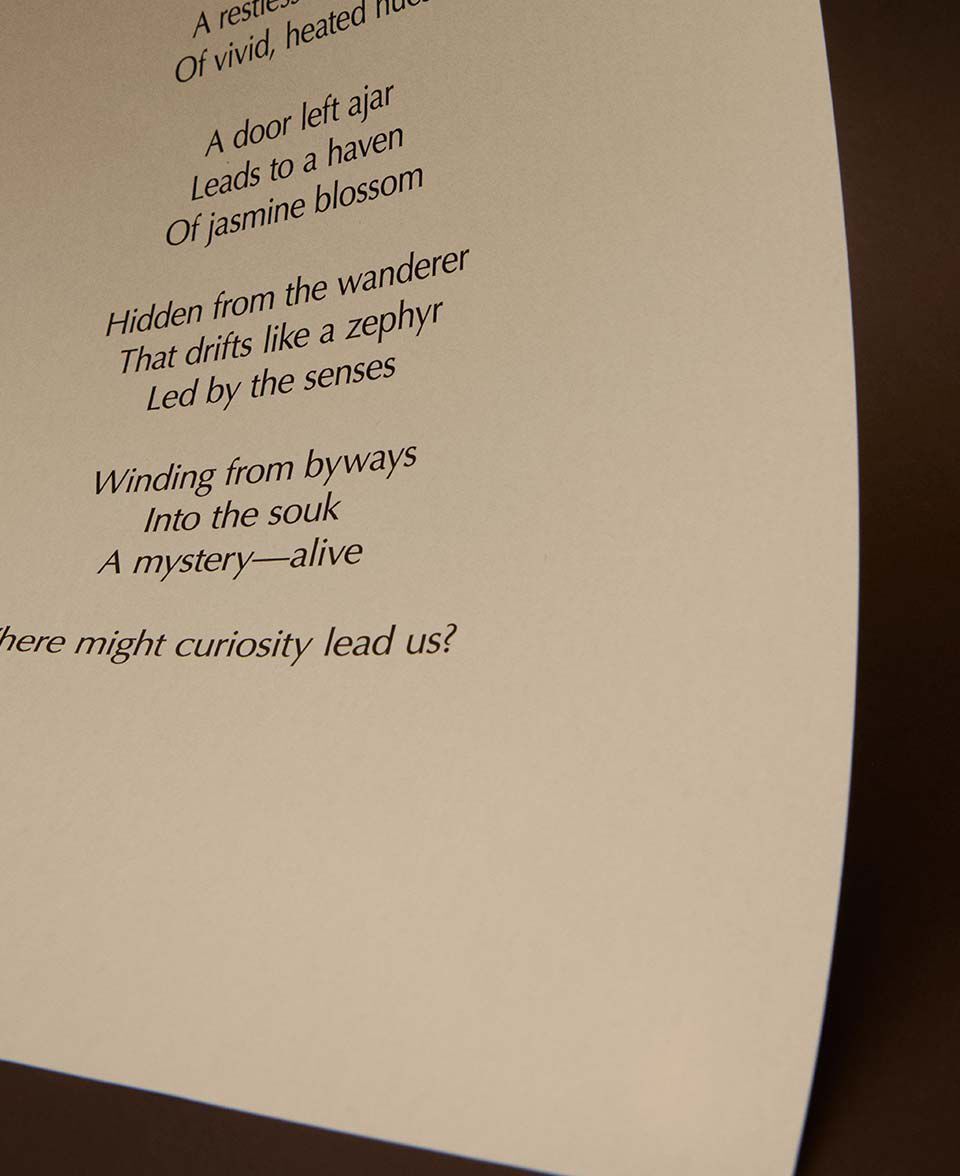 Close-up of printed poem lines on a curved cream paper sheet.